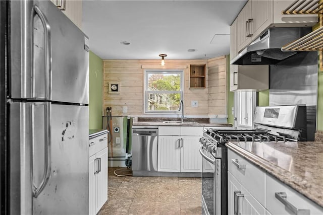 kitchen featuring stainless steel appliances, a sink, white cabinets, under cabinet range hood, and light stone counters