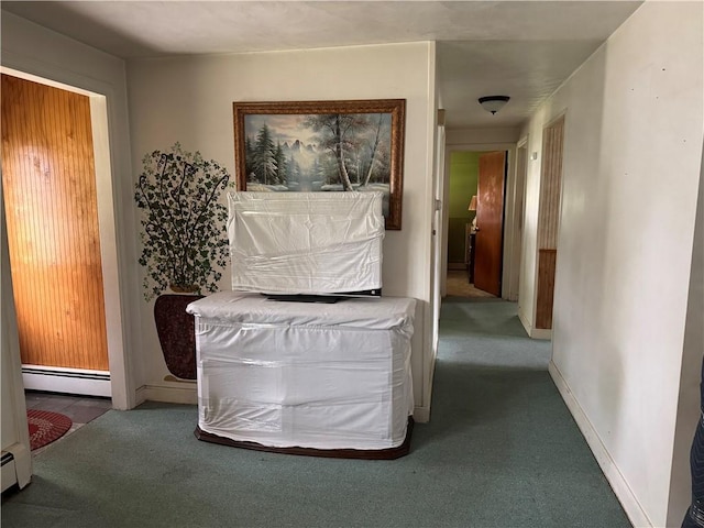 corridor featuring a baseboard heating unit, carpet floors, and baseboards
