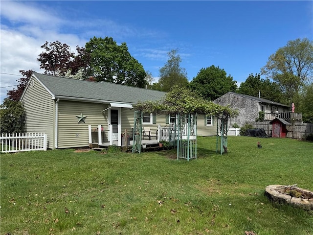 back of house featuring an outbuilding, a shed, and a fire pit