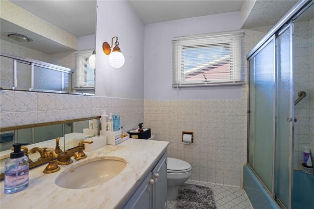 37 Pinewood Dr, North Providence, RI 02904 - full bathroom with plenty of natural light, tile patterned flooring, tile walls, vanity, and toilet
