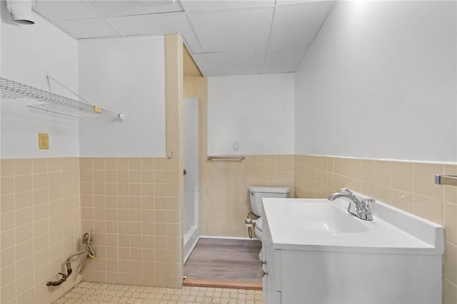 37 Pinewood Dr, North Providence, RI 02904 - bathroom featuring tile walls, a drop ceiling, wainscoting, toilet, and vanity