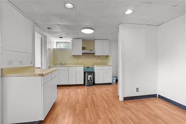37 Pinewood Dr, North Providence, RI 02904 - kitchen with a sink, light wood-style flooring, under cabinet range hood, white cabinetry, and a paneled ceiling