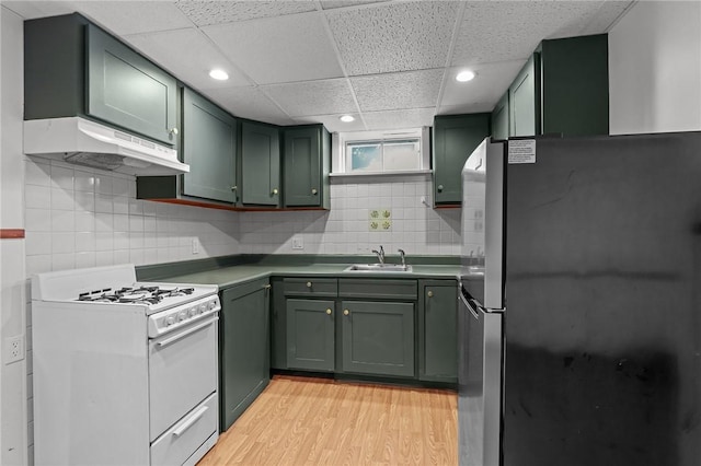 37 Pinewood Dr, North Providence, RI 02904 - kitchen with green cabinetry, white gas stove, freestanding refrigerator, under cabinet range hood, and a sink