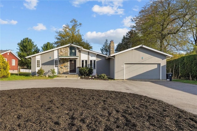 37 Pinewood Dr, North Providence, RI 02904 - mid-century modern home featuring a chimney, a garage, stone siding, and asphalt driveway