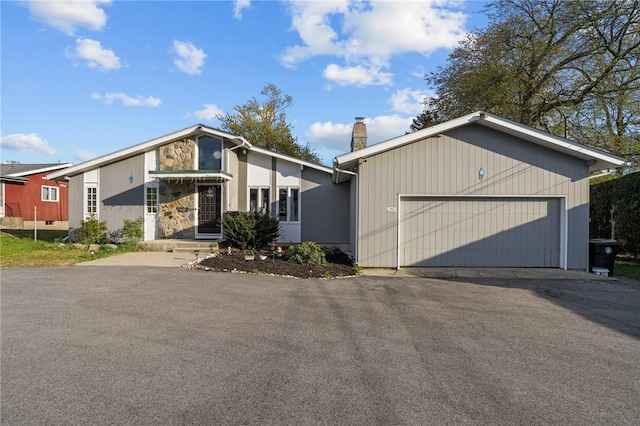 37 Pinewood Dr, North Providence, RI 02904 - mid-century modern home featuring a chimney, an attached garage, driveway, and stone siding