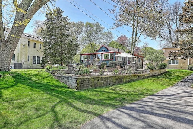 view of front of property with cooling unit and a front lawn