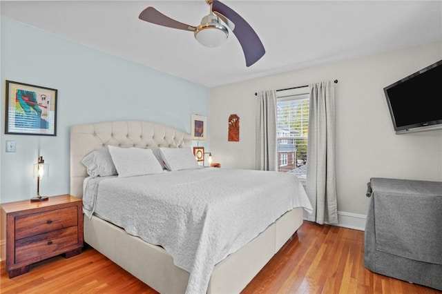 bedroom with wood finished floors, a ceiling fan, and baseboards