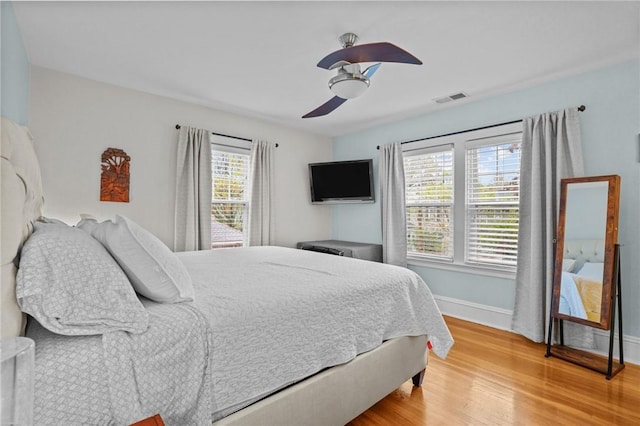 bedroom with baseboards, light wood finished floors, and ceiling fan