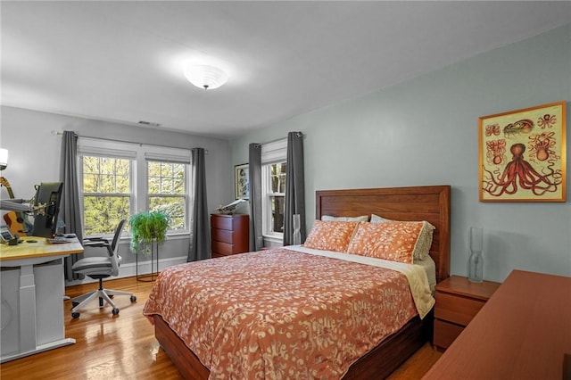 bedroom with wood finished floors and a desk