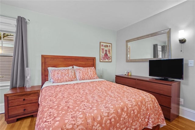 bedroom featuring wood finished floors and baseboards