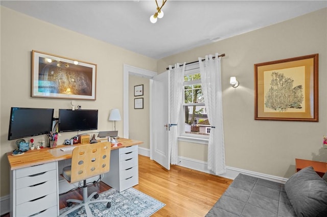 home office with light wood-type flooring and baseboards