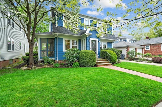 view of front of house with a shingled roof and a front yard