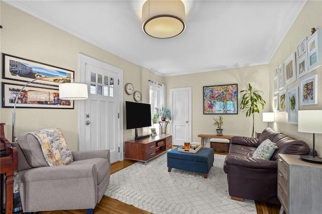 living room with wood finished floors and crown molding