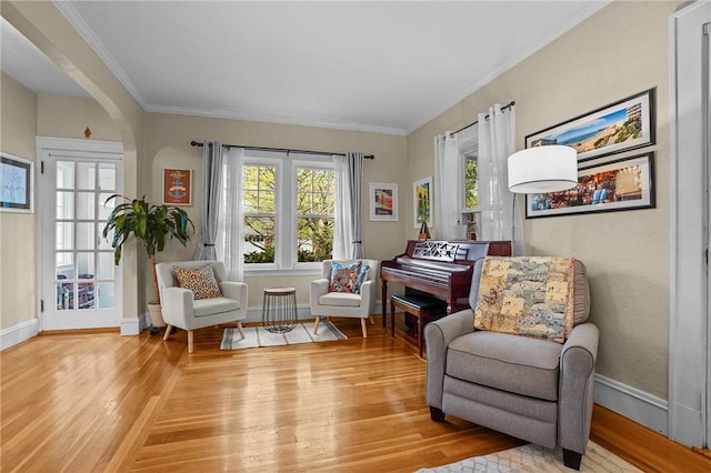 sitting room featuring hardwood / wood-style floors, baseboards, and crown molding