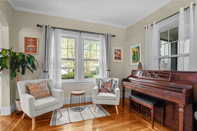 living area featuring ornamental molding, wood finished floors, and baseboards