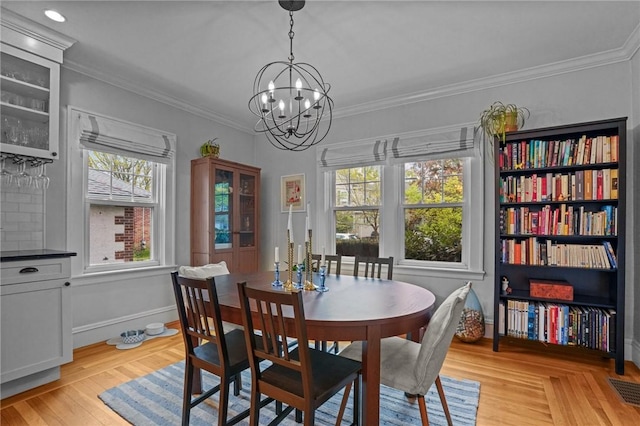 dining area featuring a chandelier, crown molding, and baseboards