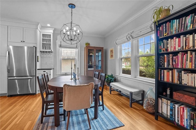 dining area featuring a chandelier, light wood finished floors, crown molding, and recessed lighting