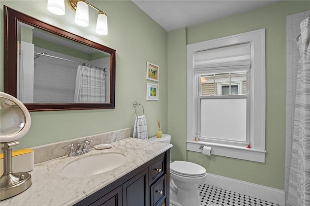 full bathroom with baseboards, vanity, and toilet