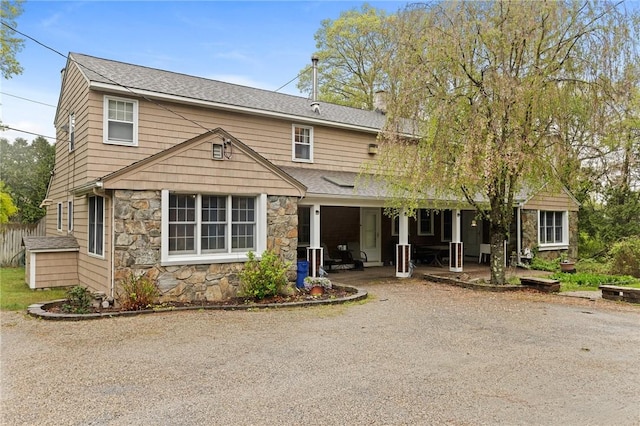 24 Golden View Dr, Johnston, RI 02919 - view of front facade featuring stone siding, a chimney, roof with shingles, and a porch