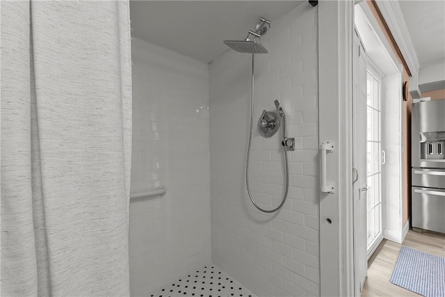 bathroom featuring tiled shower and wood finished floors