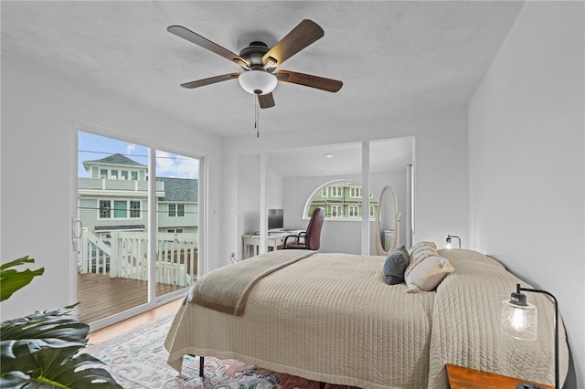 bedroom featuring access to outside, wood finished floors, and a ceiling fan