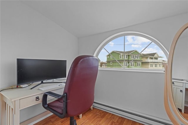 office featuring baseboard heating, light wood-type flooring, and vaulted ceiling