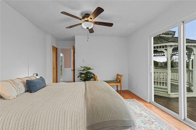 bedroom with access to outside, light wood-type flooring, baseboards, and ceiling fan
