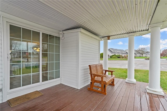 wooden deck featuring covered porch and a lawn