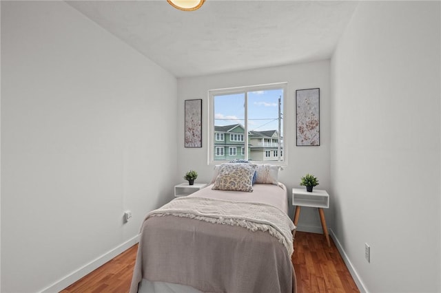 bedroom with baseboards and wood finished floors