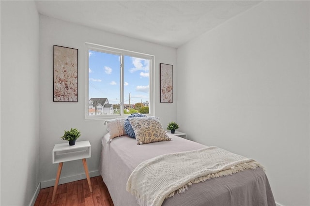 bedroom with wood finished floors and baseboards