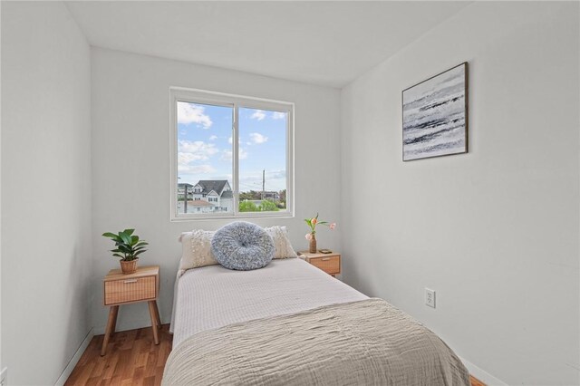 bedroom featuring wood finished floors and baseboards