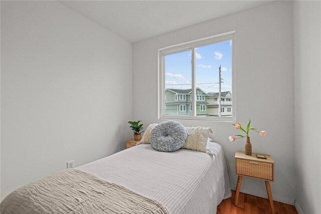 bedroom featuring wood finished floors and baseboards