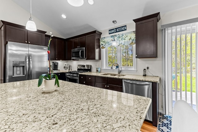 1740 Bulgarmarsh Rd, Tiverton, RI 02878 - kitchen featuring appliances with stainless steel finishes, a sink, dark brown cabinetry, light stone counters, and decorative light fixtures
