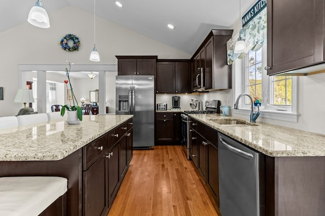 1740 Bulgarmarsh Rd, Tiverton, RI 02878 - kitchen with appliances with stainless steel finishes, a sink, light stone counters, dark brown cabinetry, and hanging light fixtures