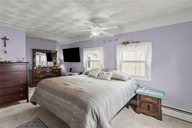 carpeted bedroom with a baseboard radiator and a ceiling fan