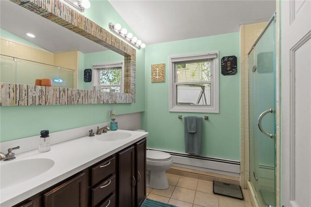 bathroom featuring a baseboard heating unit, tile patterned flooring, an enclosed shower, toilet, and double vanity