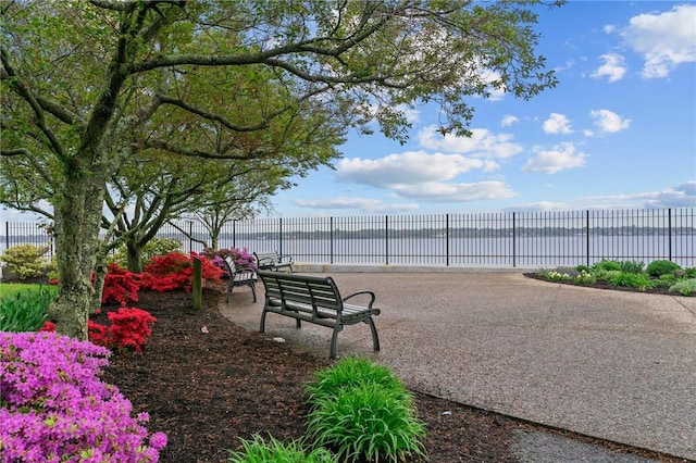view of property's community featuring fence and a water view