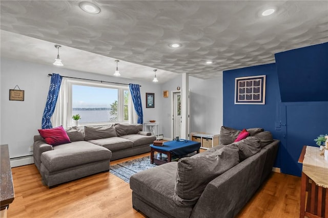 living area with wood finished floors, a baseboard heating unit, and recessed lighting