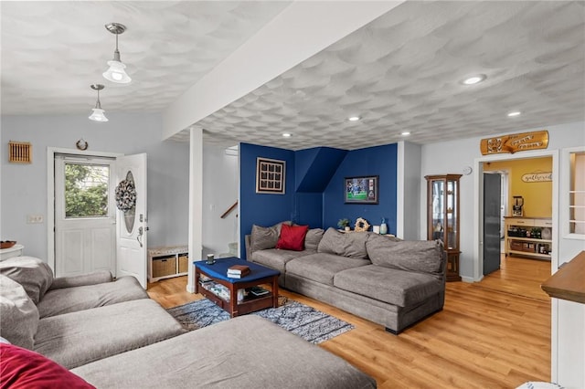 living area featuring light wood-style floors, recessed lighting, and stairs