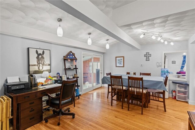 dining space featuring light wood-style flooring, a desk, and beamed ceiling
