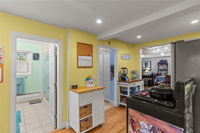 kitchen featuring a baseboard heating unit, white cabinetry, light wood-type flooring, recessed lighting, and baseboards