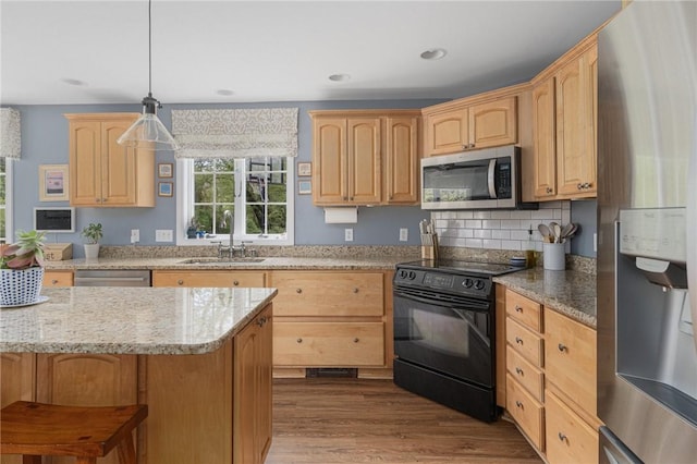 kitchen featuring appliances with stainless steel finishes, a sink, light brown cabinets, light stone counters, and dark wood-style floors