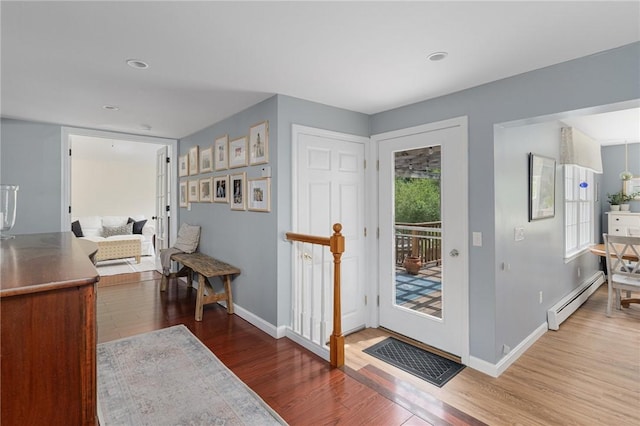 entrance foyer featuring a baseboard heating unit, wood finished floors, and baseboards