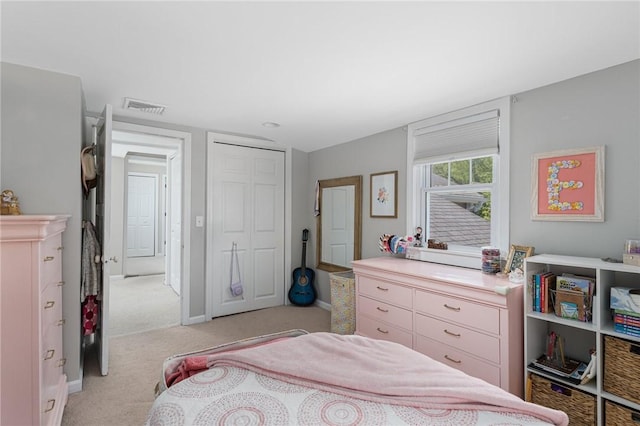 bedroom with light carpet, a closet, and baseboards