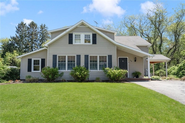 traditional home featuring a front yard and asphalt driveway