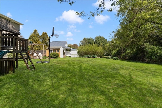 view of yard featuring a playground and an outbuilding