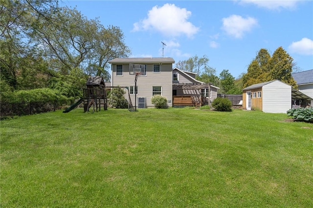 back of property with a playground and an outbuilding