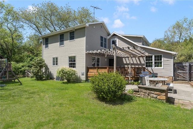 rear view of property with a pergola, a wooden deck, and a patio