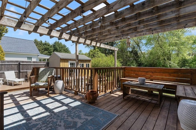 deck featuring fence, an outbuilding, and a pergola