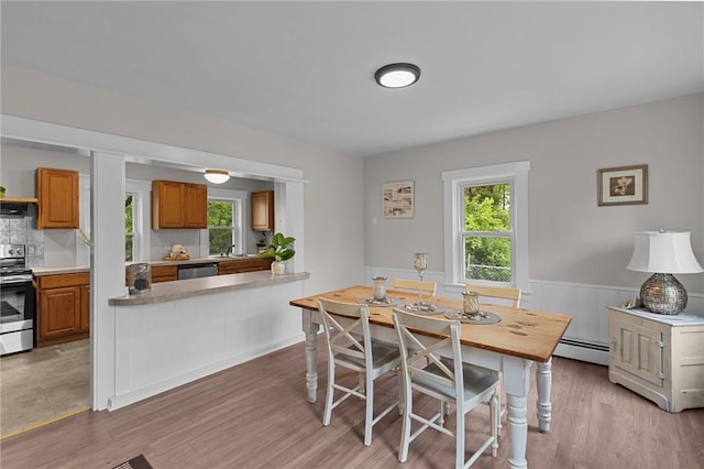 183 Annaquatucket Rd, North Kingstown, RI 02852 - dining area featuring baseboard heating, healthy amount of natural light, light wood finished floors, and wainscoting